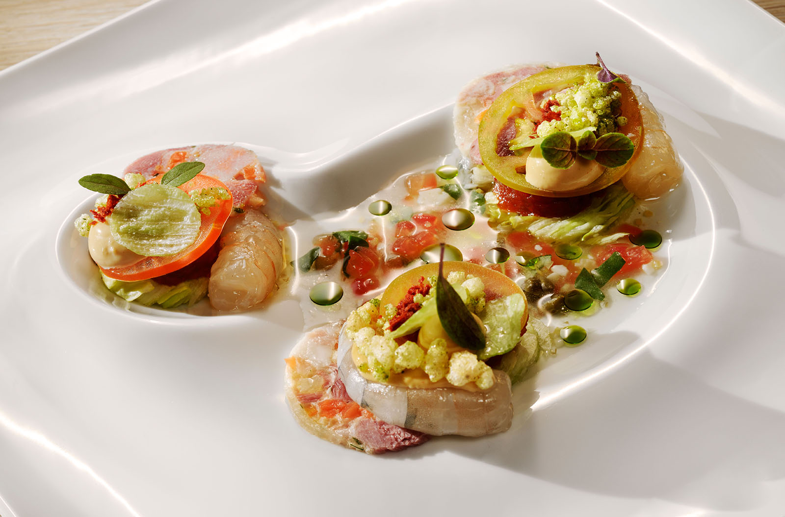 Confierte Cristallgarnele, geschmolzene Ferkelzampone und Tomatensud