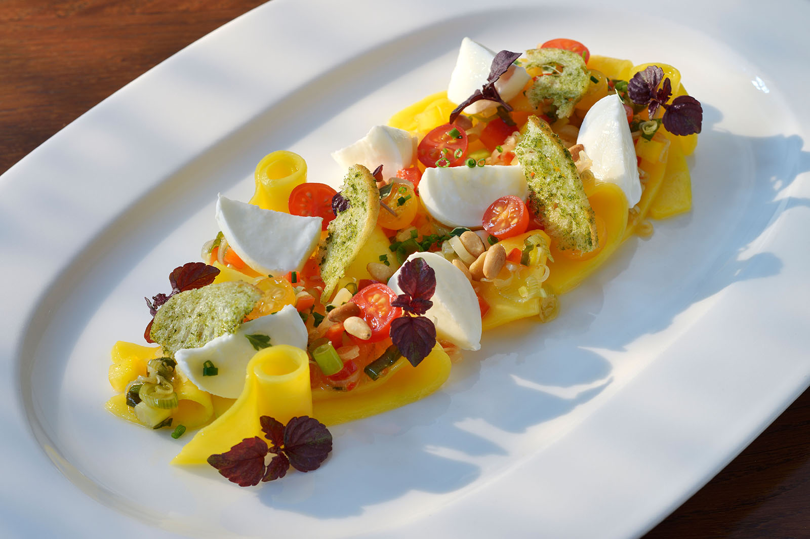 Mango-Mozzarella-Salat mit Zitronengras und Paprika angerichtet von unserem Küchenchef Timo Schröder.