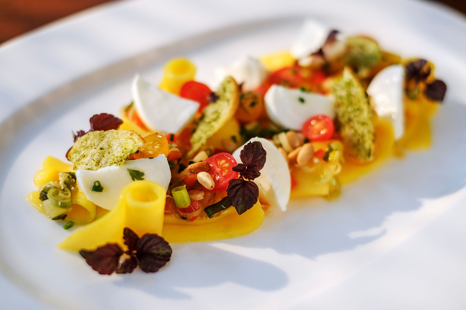 Mango-Mozzarella-Salat mit Zitronengras und Paprika angerichtet von unserem Küchenchef Timo Schröder.