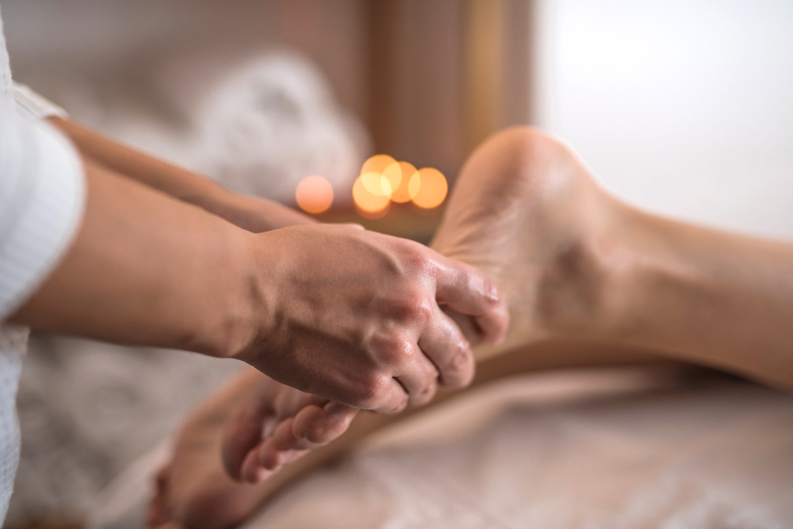 Close Up einer Fußmassage im Hintergrund Kerzen